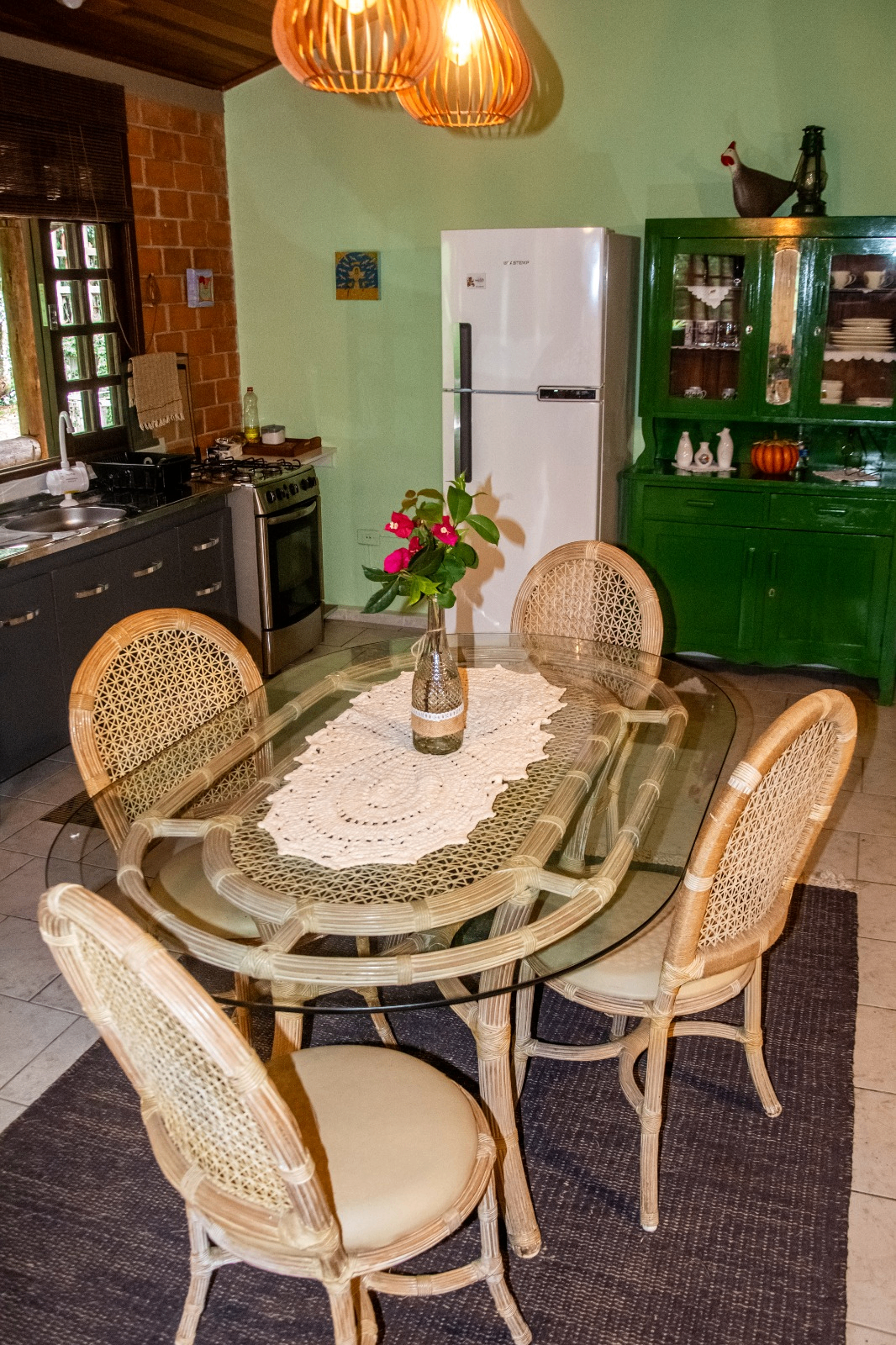 Cozinha e mesa de jantar com cadeiras de palhinha