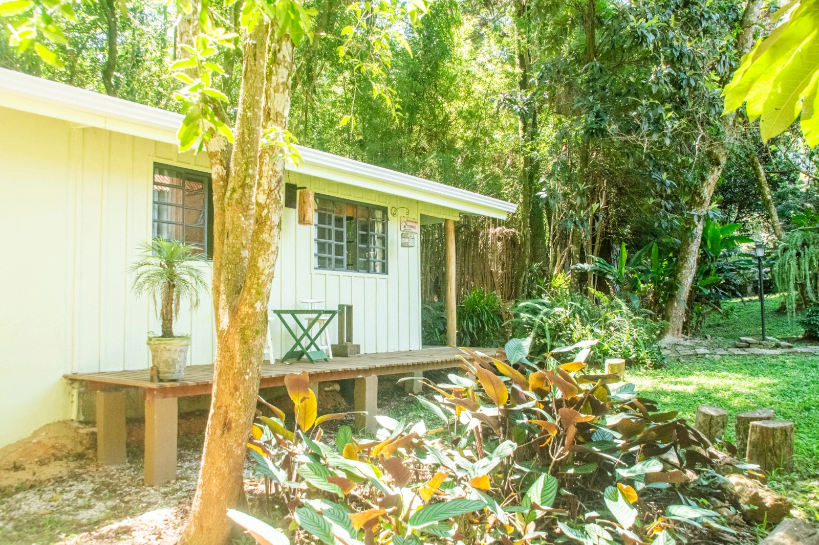 Chalé branco rodeado pelo jardim